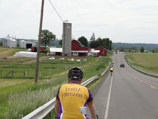 photo of bicyclist riding down country road