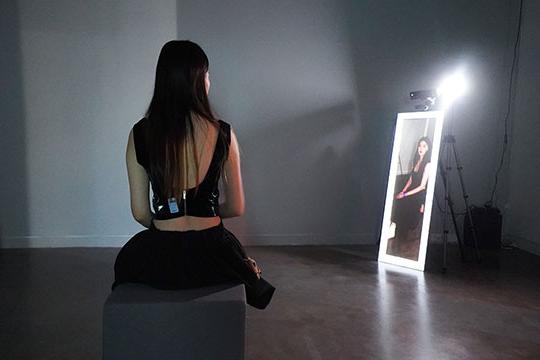 woman sitting, artwork in background